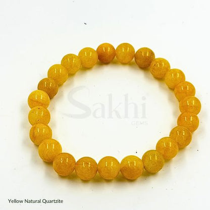 A yellow natural quartzite bracelet with round beads, displayed against a white background with the brand name 'Sakhi' visible.